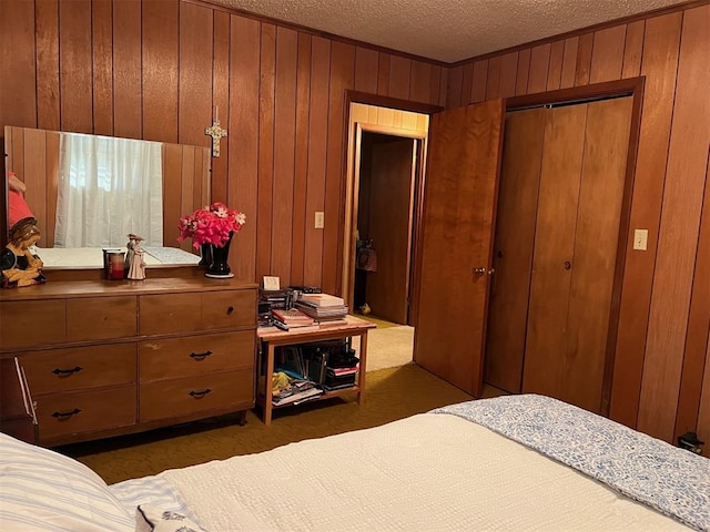 bedroom featuring a closet, wood walls, a textured ceiling, and dark colored carpet