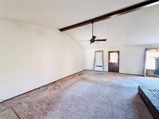 unfurnished living room featuring carpet floors, a textured ceiling, lofted ceiling with beams, and ceiling fan