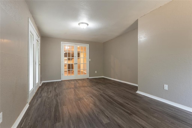 empty room featuring dark hardwood / wood-style floors and french doors