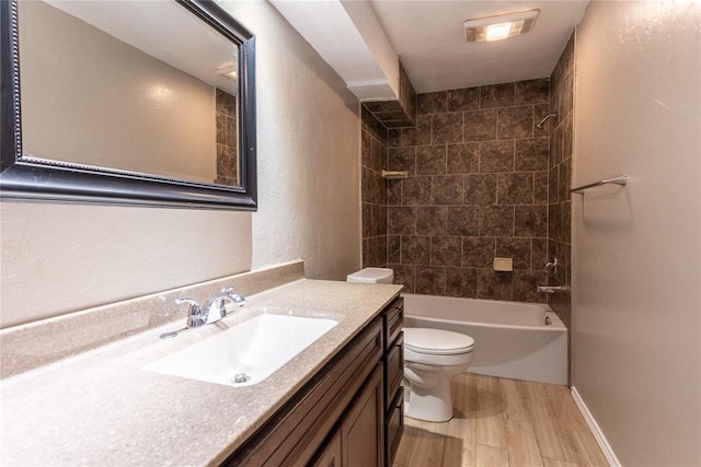 full bathroom featuring vanity, toilet, hardwood / wood-style floors, and tiled shower / bath