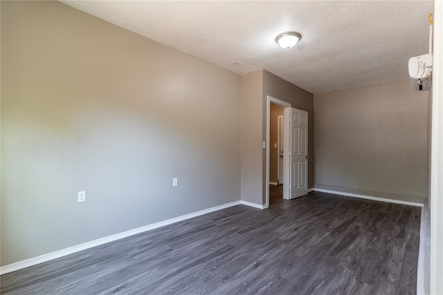 spare room featuring a textured ceiling and dark hardwood / wood-style flooring