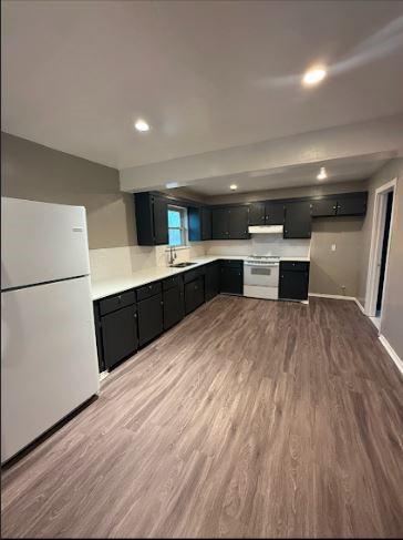 kitchen featuring sink, white appliances, and dark hardwood / wood-style floors