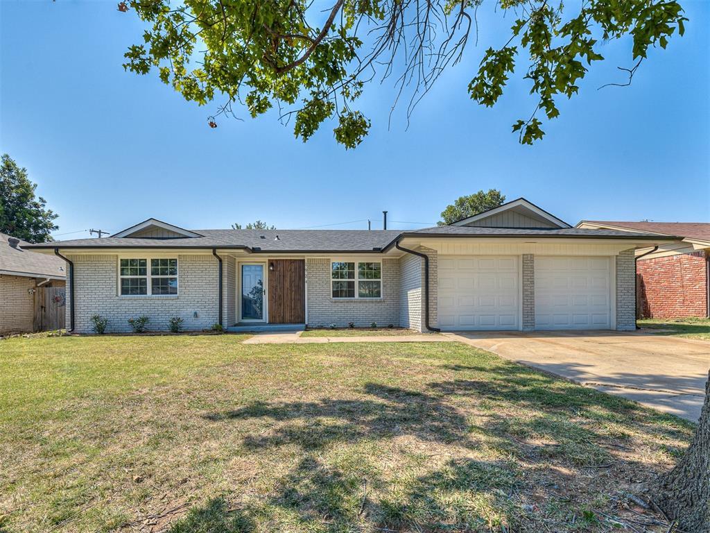 ranch-style house featuring a garage and a front yard