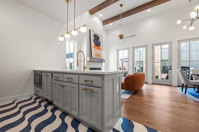 kitchen with sink, decorative light fixtures, beamed ceiling, ceiling fan, and gray cabinetry