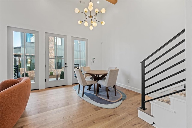 dining room featuring a notable chandelier, light hardwood / wood-style flooring, and plenty of natural light