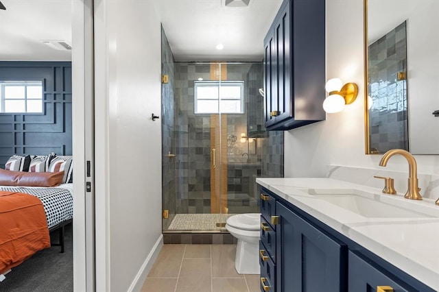 bathroom featuring toilet, tile patterned flooring, vanity, and a shower with shower door