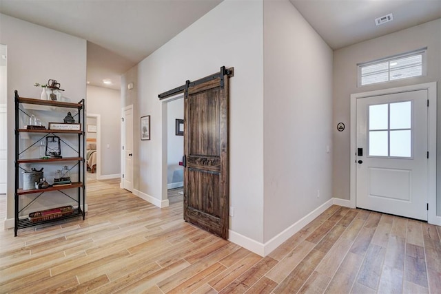 entrance foyer with light hardwood / wood-style flooring and a barn door