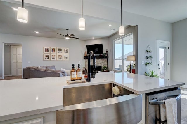 kitchen with decorative light fixtures, ceiling fan, hardwood / wood-style floors, and sink