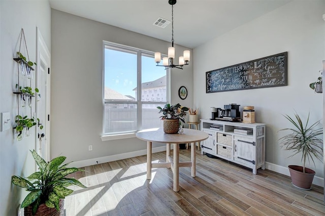 dining area with an inviting chandelier and light hardwood / wood-style floors