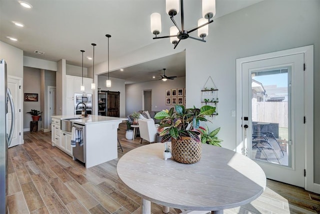 dining room with sink and ceiling fan with notable chandelier