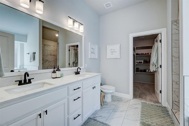 bathroom featuring toilet, vanity, and walk in shower