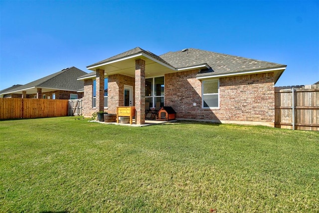 back of house with a patio area and a lawn