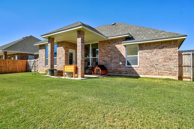 rear view of property featuring a lawn and a patio area