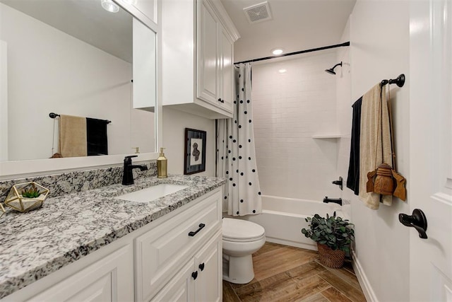 full bathroom with vanity, hardwood / wood-style flooring, shower / bath combination with curtain, and toilet