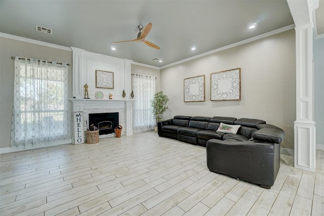 living room with ornamental molding, ceiling fan, and light wood-type flooring