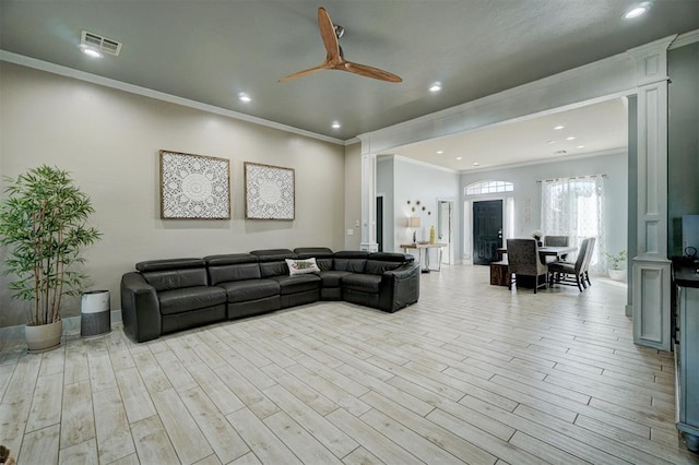 living room with ceiling fan and ornamental molding