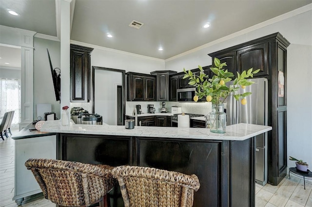 kitchen with light wood-type flooring, a center island, backsplash, and crown molding