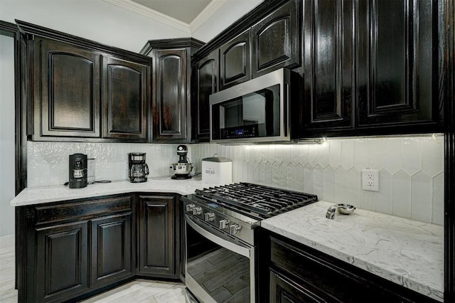 kitchen with backsplash, crown molding, and appliances with stainless steel finishes