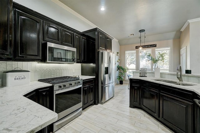 kitchen featuring sink, ornamental molding, tasteful backsplash, hanging light fixtures, and appliances with stainless steel finishes