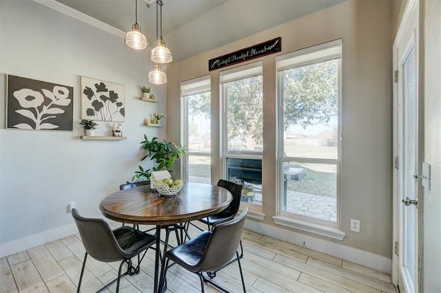 dining area with light wood-type flooring and crown molding