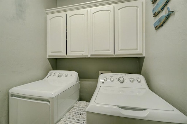 clothes washing area featuring cabinets and independent washer and dryer