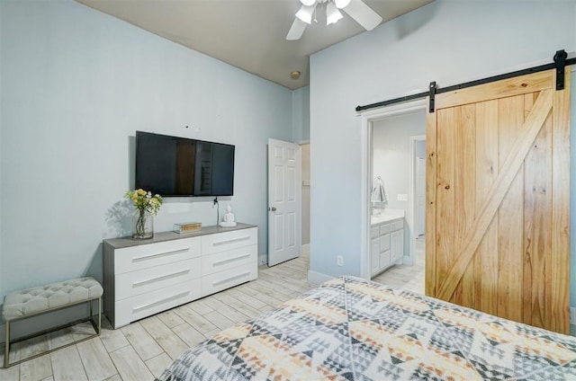 bedroom featuring ensuite bathroom, ceiling fan, and a barn door