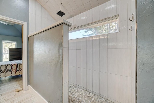 bathroom featuring lofted ceiling and a shower