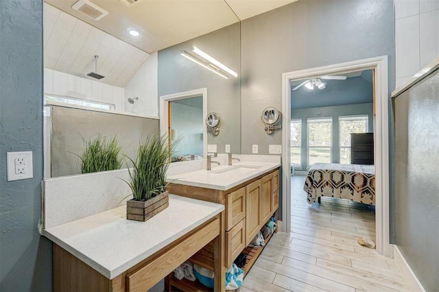 bathroom featuring lofted ceiling, walk in shower, and vanity