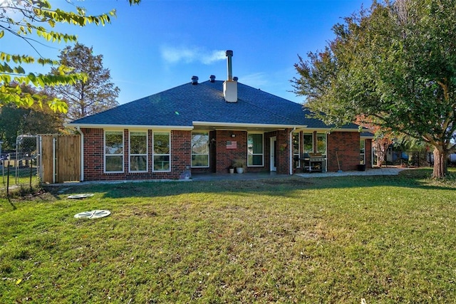 rear view of property featuring a yard