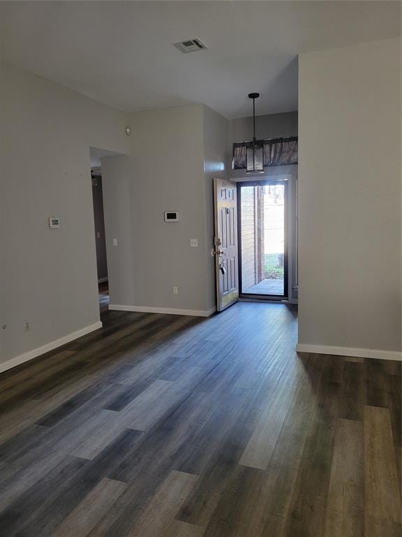 foyer entrance with dark wood-type flooring and a chandelier