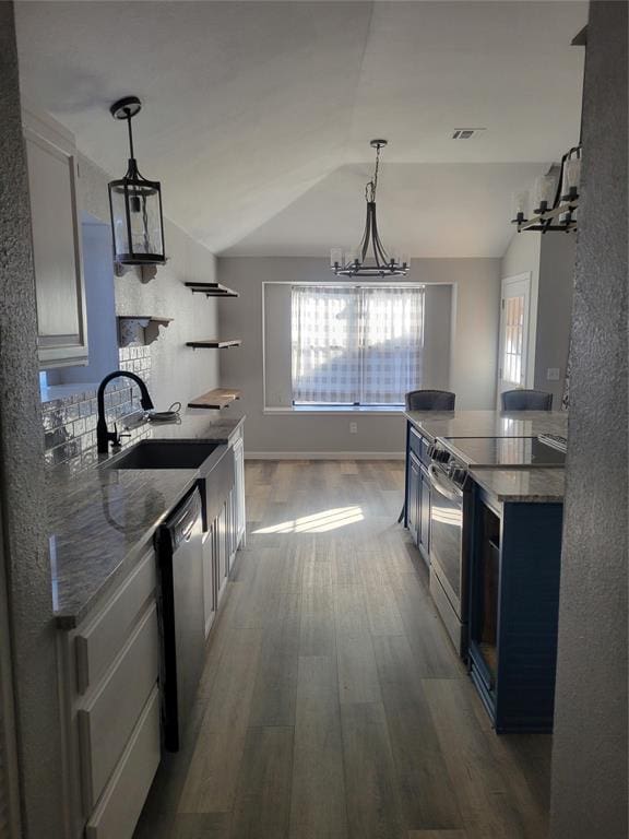 kitchen with vaulted ceiling, a notable chandelier, sink, white cabinetry, and appliances with stainless steel finishes