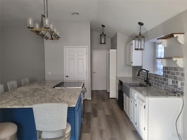 kitchen featuring black dishwasher, decorative backsplash, white cabinets, and hanging light fixtures