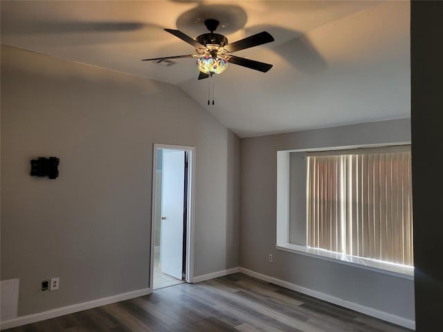 empty room featuring vaulted ceiling, ceiling fan, and dark hardwood / wood-style floors