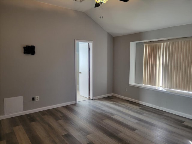 empty room featuring ceiling fan, dark hardwood / wood-style flooring, and vaulted ceiling