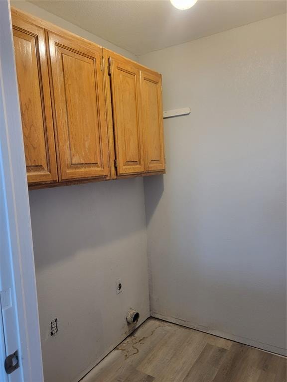 washroom featuring cabinets, light hardwood / wood-style flooring, and hookup for an electric dryer