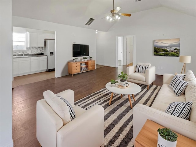 living room featuring ceiling fan, vaulted ceiling, and dark hardwood / wood-style flooring