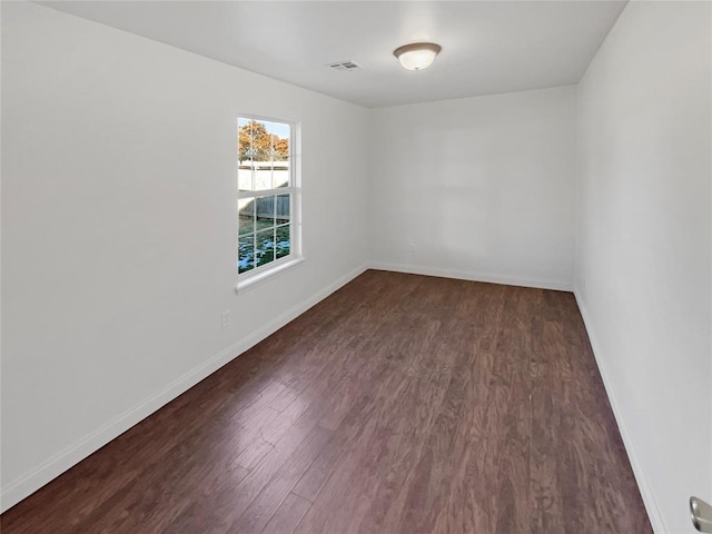 spare room featuring dark wood-type flooring