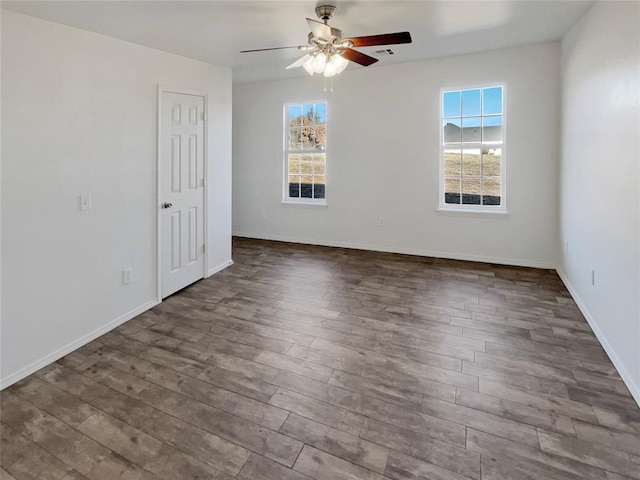 unfurnished room with ceiling fan and dark hardwood / wood-style flooring