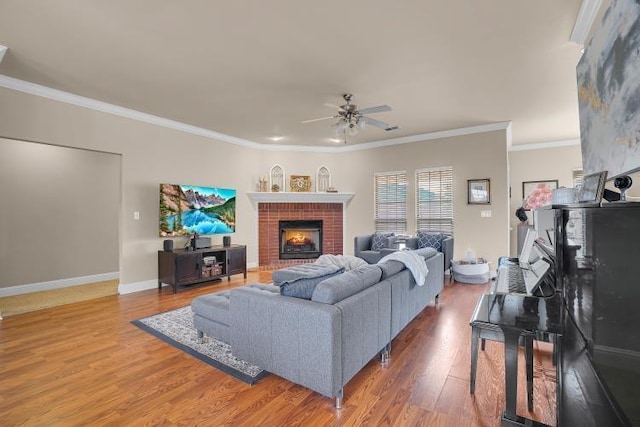 living room featuring ceiling fan, ornamental molding, hardwood / wood-style floors, and a brick fireplace