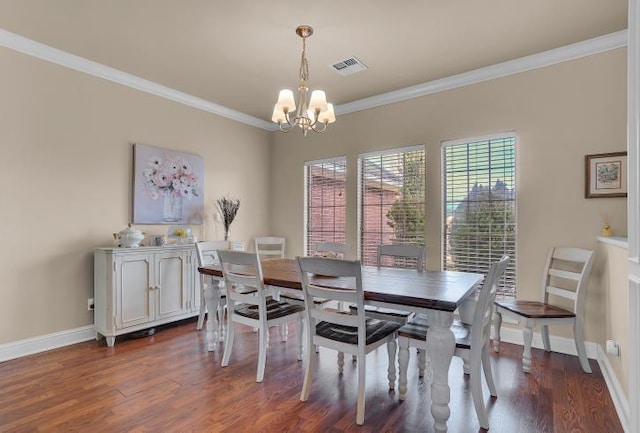 dining area featuring crown molding, dark hardwood / wood-style flooring, and an inviting chandelier