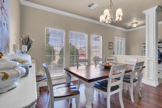 dining room with crown molding, dark hardwood / wood-style flooring, decorative columns, and a notable chandelier