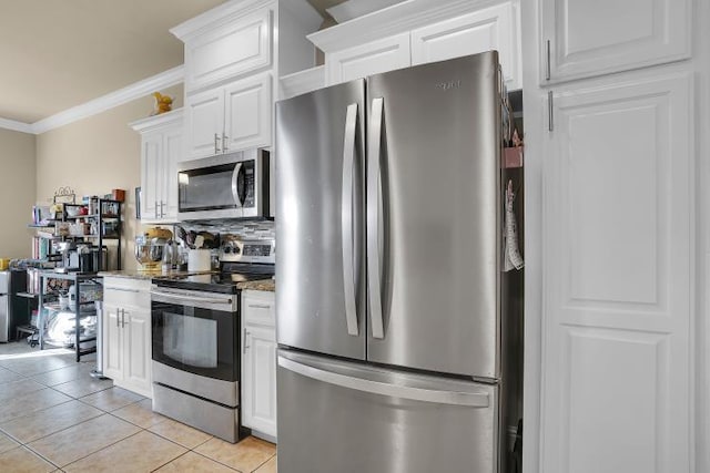 kitchen featuring light tile patterned floors, stainless steel appliances, ornamental molding, white cabinets, and stone countertops