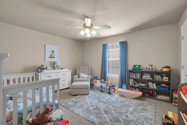 bedroom with a crib, carpet floors, and ceiling fan