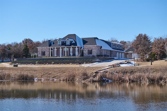 rear view of property featuring a water view and a garage