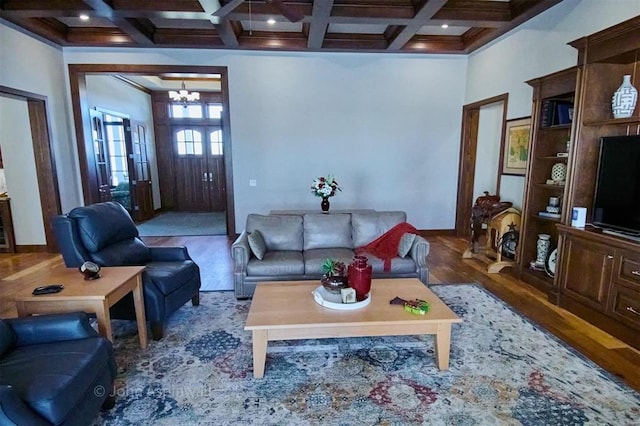 living room featuring wood-type flooring, a notable chandelier, beamed ceiling, and coffered ceiling