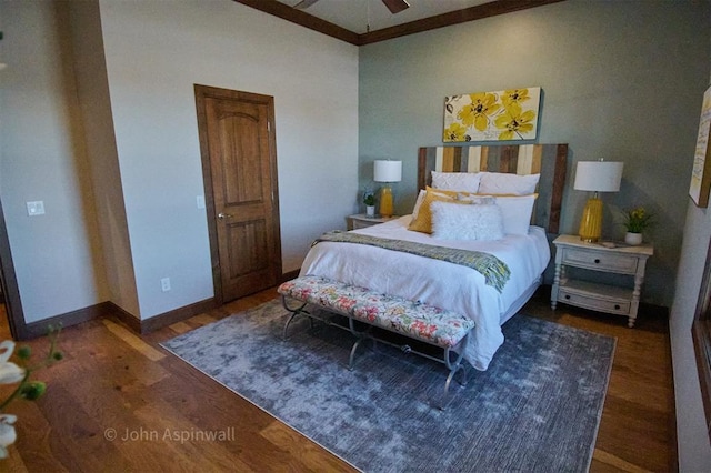 bedroom with ceiling fan, crown molding, and dark wood-type flooring