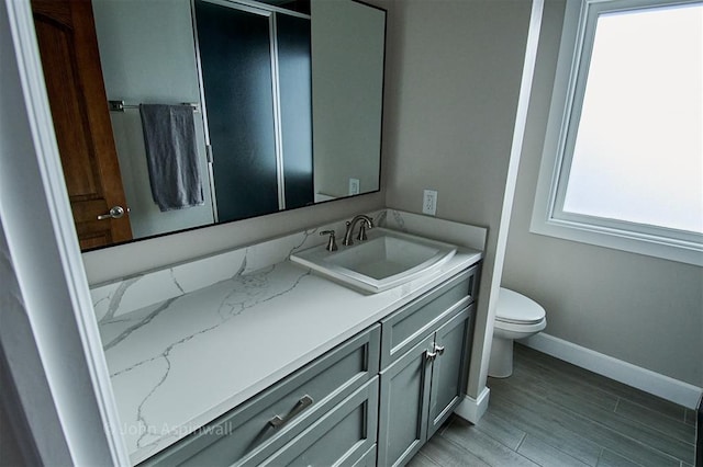 bathroom with vanity, toilet, and hardwood / wood-style flooring