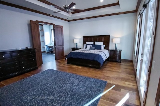 bedroom featuring ceiling fan, dark hardwood / wood-style floors, a raised ceiling, and ornamental molding