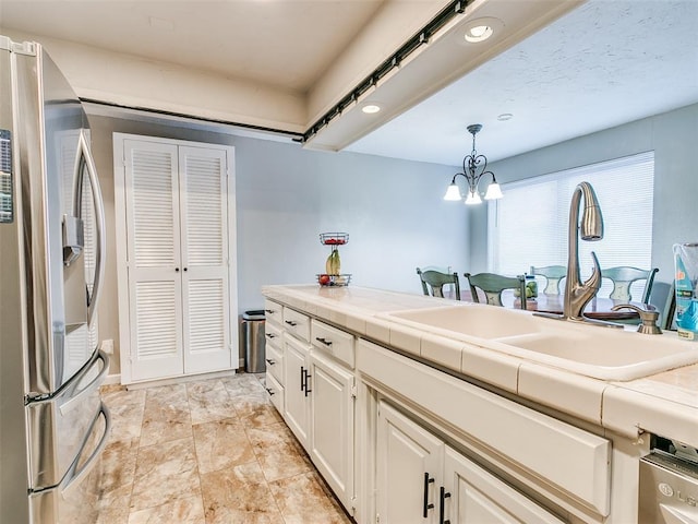 kitchen with pendant lighting, white cabinets, tile counters, sink, and stainless steel fridge with ice dispenser