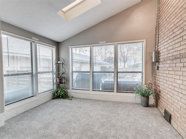 carpeted empty room with lofted ceiling with skylight